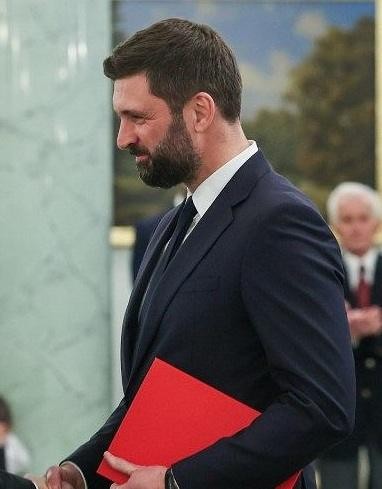 Nikodem Rachoń podczas konferencji lub spotkania, symbolizującego jego aktywną rolę w polityce międzynarodowej.
