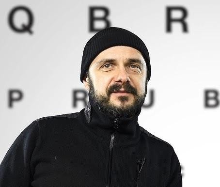 Arkadiusz Jakubik w dynamicznej scenie, ukazującej jego intensywną grę aktorską.