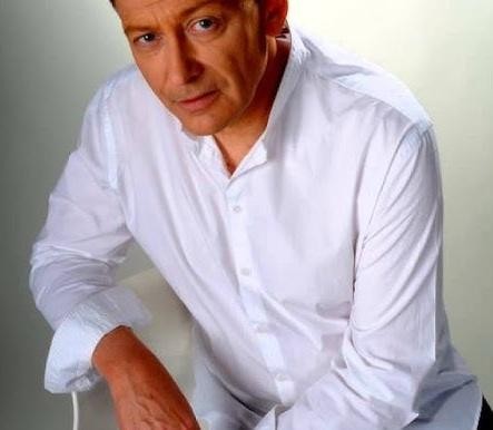 Jacek Borkowski w studiu nagraniowym, z mikrofonem i słuchawkami, podczas pracy nad dubbingiem.