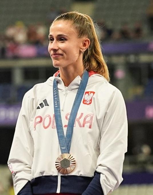 Natalia Bukowiecka w momencie skupienia lub triumfu podczas biegu na 400 metrów, ubrana w strój sportowy.