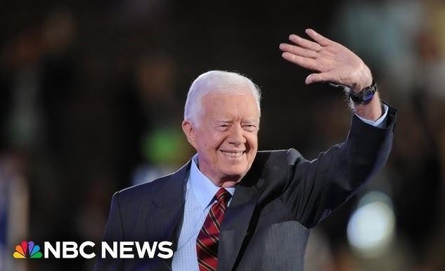 Jimmy Carter podczas budowy domu dla Habitat for Humanity, symbolizujący jego aktywne zaangażowanie w działalność humanitarną po prezydenturze.