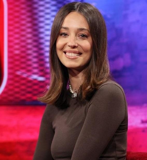 Izabella Krzan dynamicznie prezentująca program w studiu telewizyjnym.