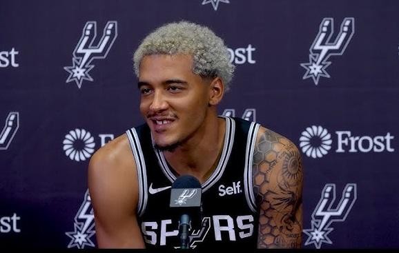 Jeremy Sochan celebrujący udaną akcję na boisku koszykarskim w koszulce San Antonio Spurs.