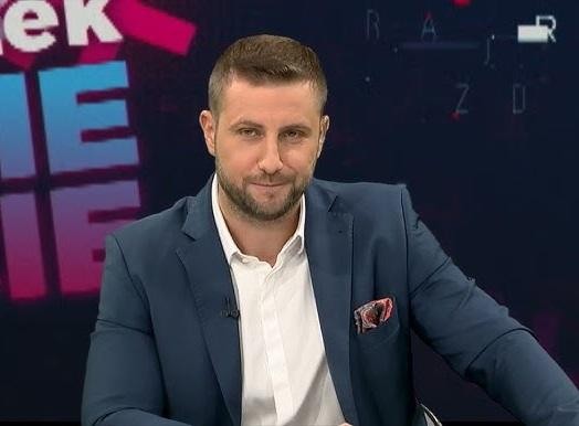 Miłosz Kłeczek podczas ożywionej debaty w studiu telewizyjnym.